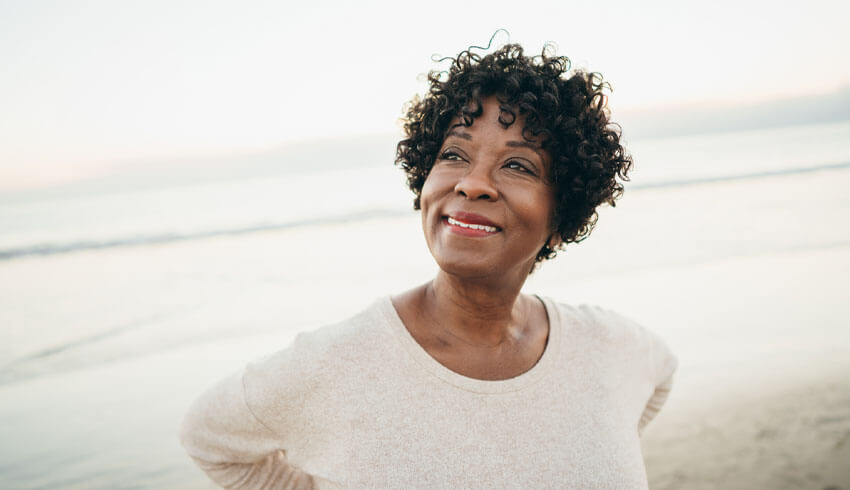 A smiling woman standing on the beach
